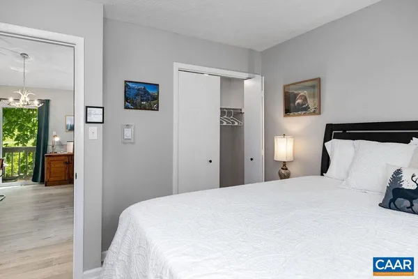 a bedroom with a bed and painting on the wall