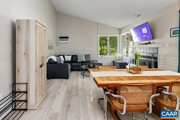 a living room with furniture a fireplace and a floor to ceiling window