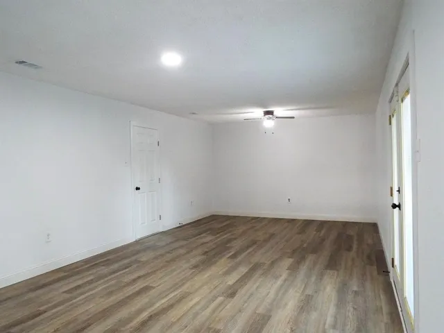 a view of empty room with wooden floor