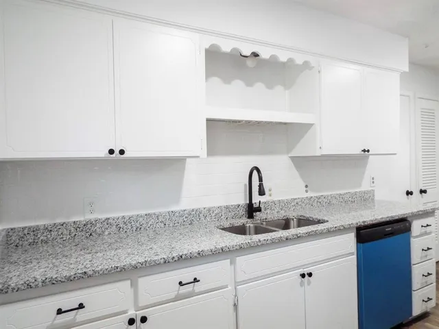 a kitchen with granite countertop a sink and cabinets
