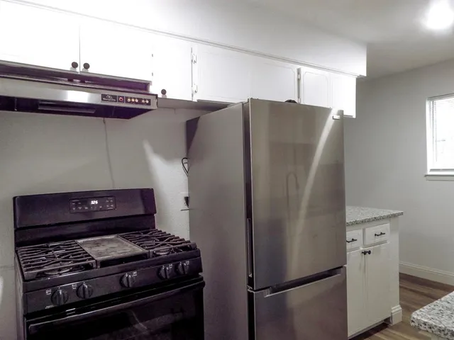 a kitchen with stainless steel appliances granite countertop a refrigerator and a stove