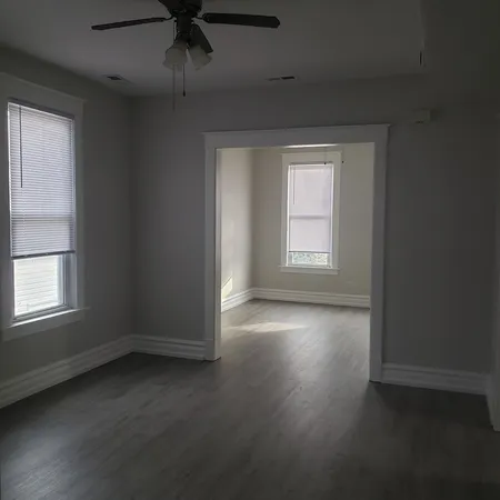 an empty room with a window and wooden floor