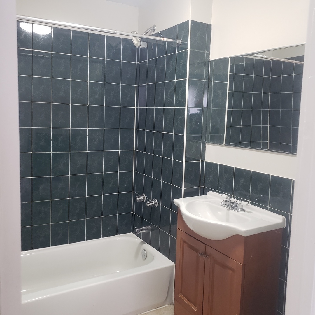 36 West 103rd Place, Unit 2 Chicago, IL 60628 - Photo 7 of 10 a bathroom with a bathtub sink and mirror
