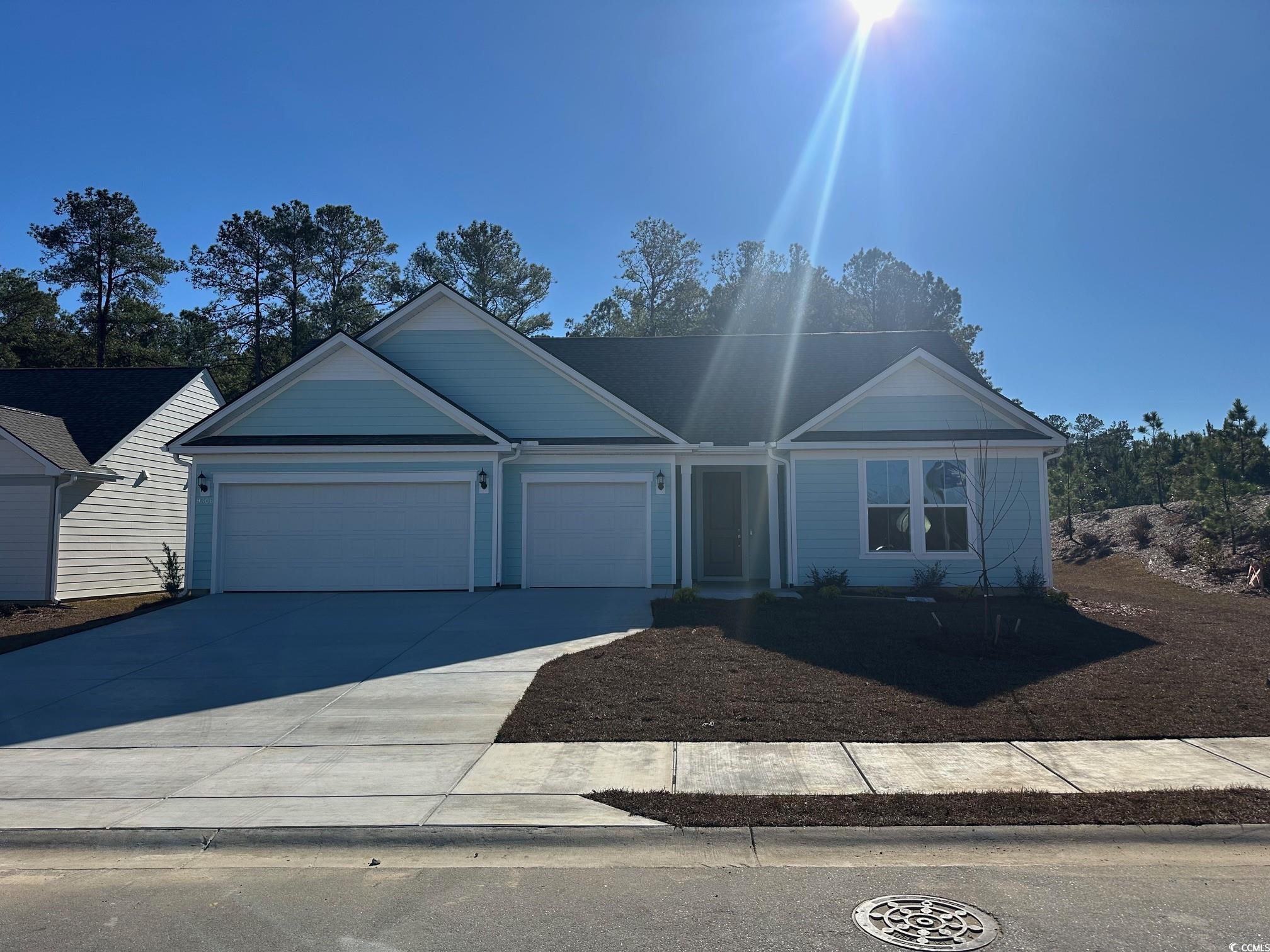 Ranch-style house featuring concrete driveway and an attached garage