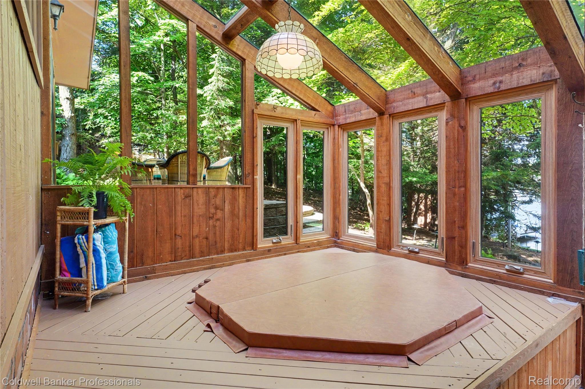 3583 Mitchell Road Metamora, MI 48455 - Photo 28 of 58 Sunroom featuring an octagonal covered hot tub, expansive window panels, exposed wood beams, wood-finish flooring, and a stained glass light fixture
