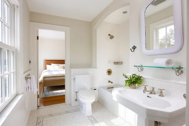 a spacious bathroom with a toilet sink and mirror