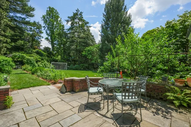 a patio with table and chairs and potted plants