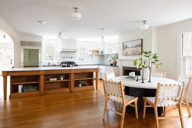 a dining hall with stainless steel appliances kitchen island granite countertop a dining table chairs and sink