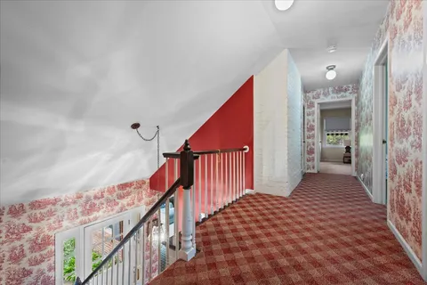 a view of a hallway with wooden floor and staircase