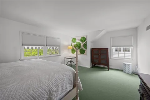 a bedroom with a bed dresser and a window