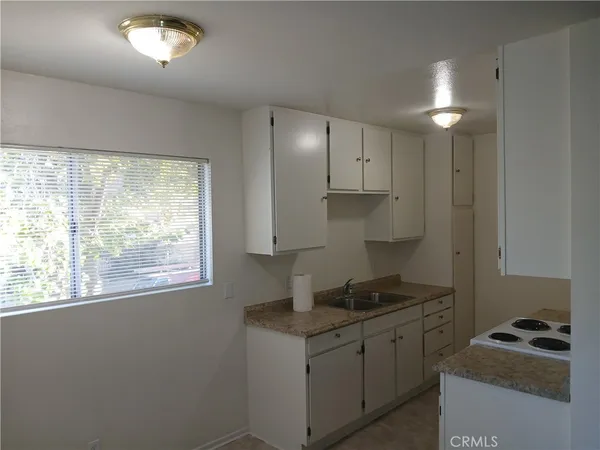 a kitchen with granite countertop a stove and a sink