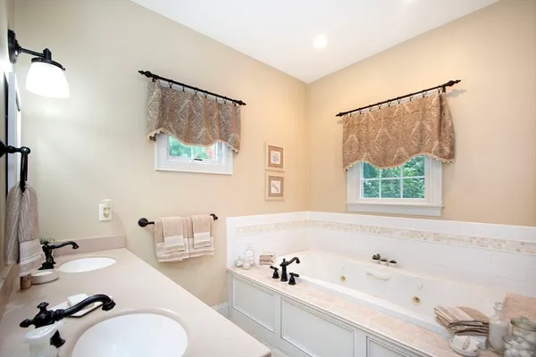 a bathroom with a tub sink and mirror