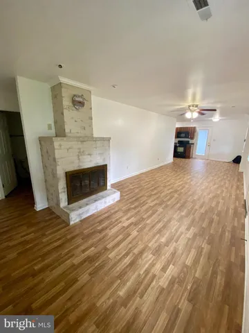 a view of empty room with wooden floor and fireplace