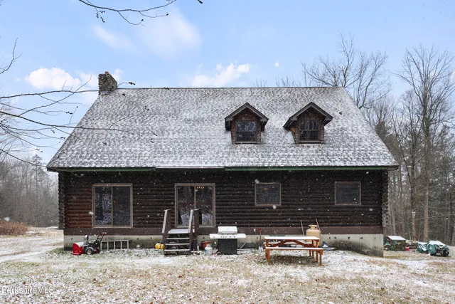 a backyard of a house with fire pit and chairs
