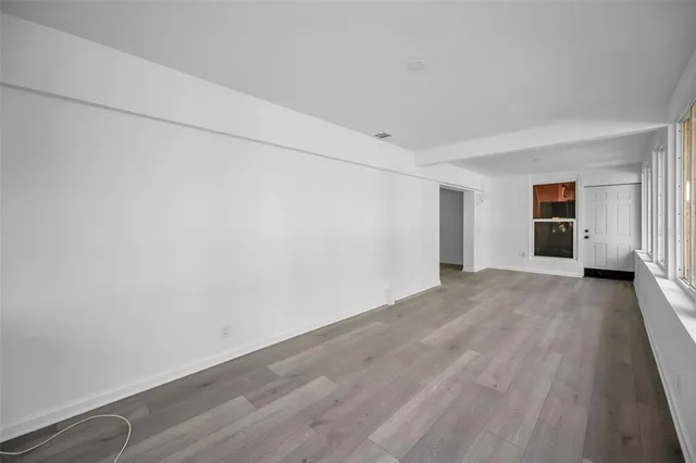 a view of an empty room with wooden floor