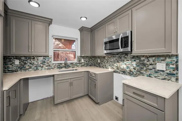 a kitchen with stainless steel appliances granite countertop a sink stove and microwave