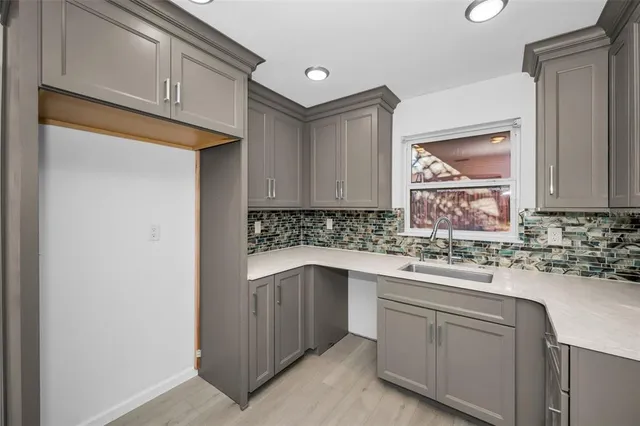 a kitchen with a sink cabinets and stove top oven