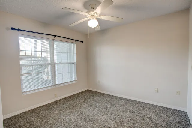 an empty room with a chandelier fan