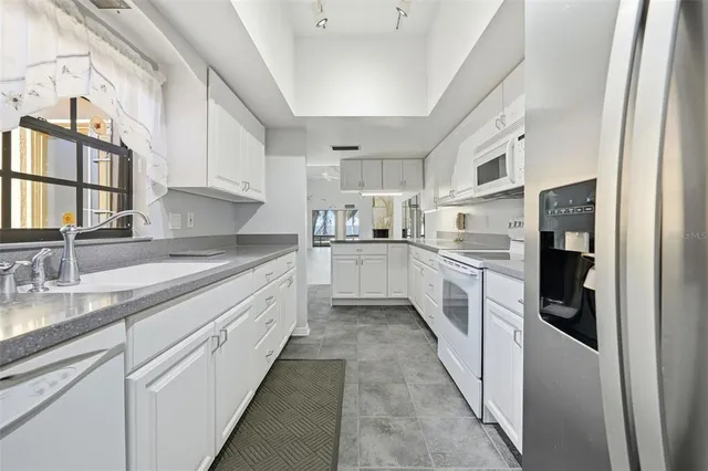 a large kitchen with stainless steel appliances lots of counter space and a sink