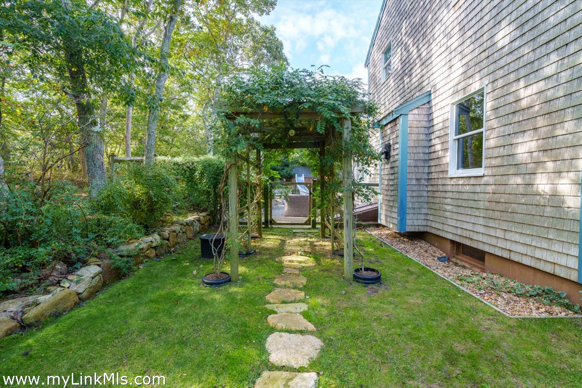 18 Cormorant Circle Edgartown, MA 02539 - Photo 32 of 42 a backyard of a house with plants and large tree