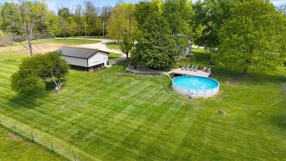 5120 Wheelock Road Troy, OH 45373 - Photo 61 of 67 Expansive green property with a large detached garage and a refreshing above-ground pool with a surrounding deck.