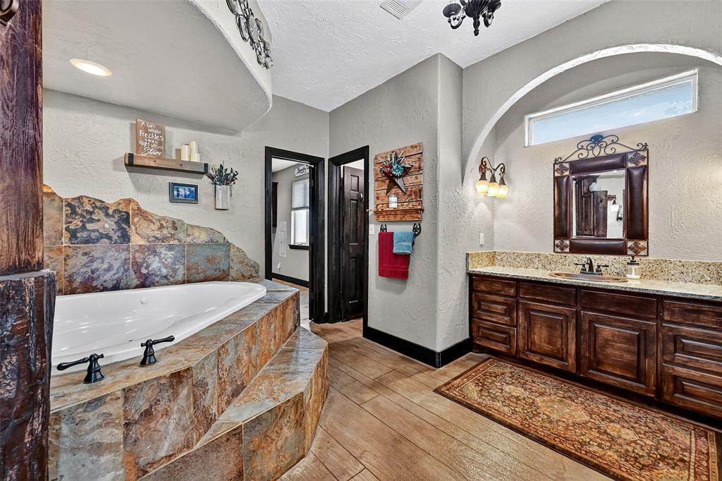 1717 1/2 Batey Road Collinsville, TX 76233 - Photo 19 of 40 a spacious bathroom with a tub and sink