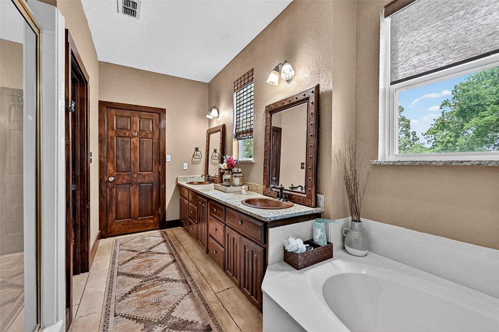 1717 1/2 Batey Road Collinsville, TX 76233 - Photo 25 of 40 a bathroom with a double vanity sink a mirror and a bathtub