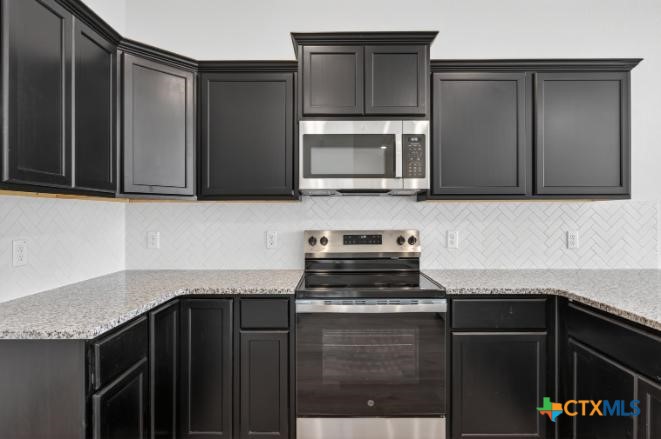 1915 Meridian Loop Temple, TX 76504 - Photo 13 of 29 a kitchen with granite countertop a stove and a microwave