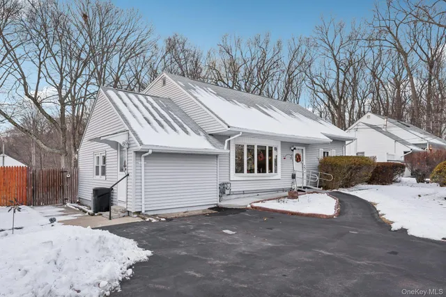a view of a white house with a snow on the road