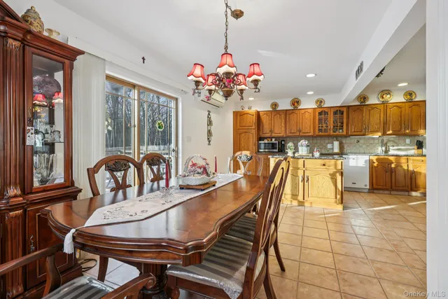 a kitchen with stainless steel appliances granite countertop table chairs and a refrigerator