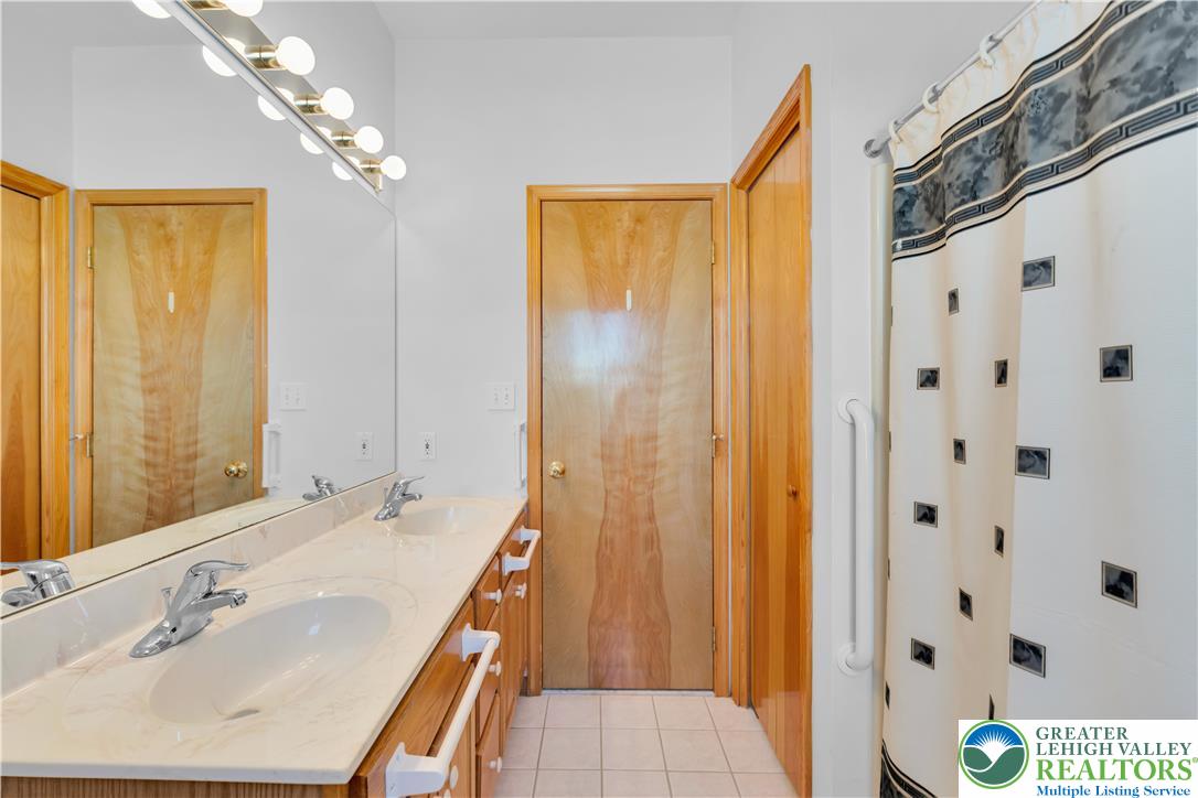 239 North 36th Street Allentown, PA 18104 - Photo 15 of 38 a bathroom with a sink a mirror and a shower