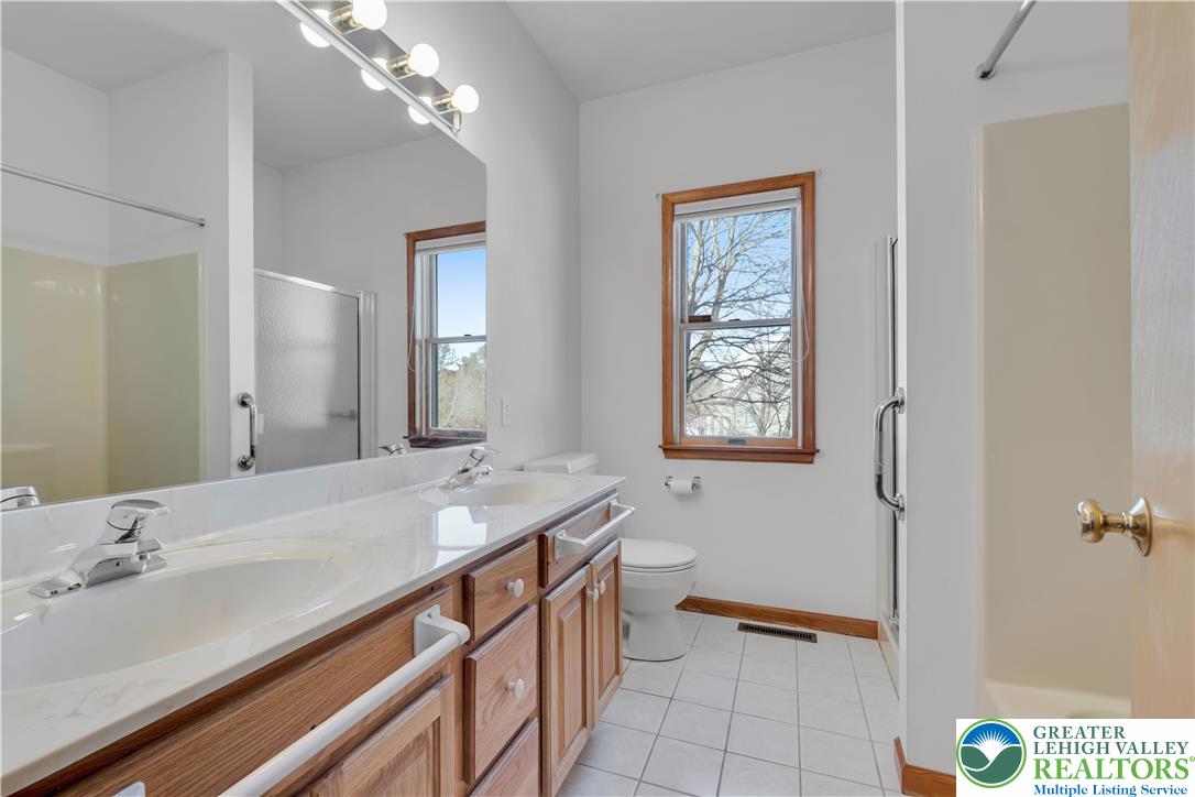 239 North 36th Street Allentown, PA 18104 - Photo 19 of 38 a bathroom with a granite countertop sink a large mirror and a shower