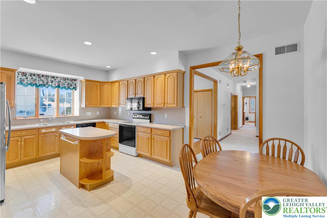 239 North 36th Street Allentown, PA 18104 - Photo 7 of 38 a kitchen with a table chairs microwave and cabinets