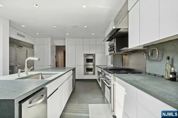a kitchen with stainless steel appliances granite countertop a sink and a stove