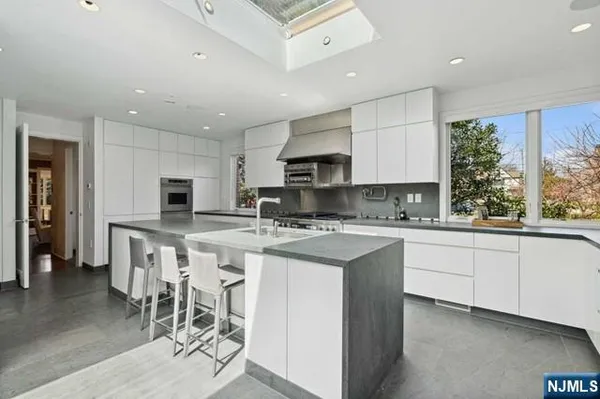 a kitchen with appliances a sink a counter top space and a center island