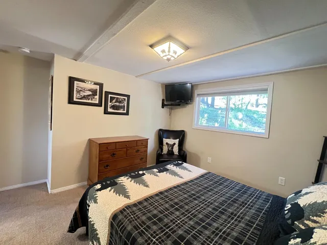 a bedroom with a bed and a tv on the dresser