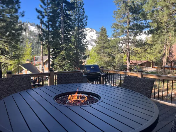 a view of a roof deck with table and chairs couches with wooden floor and fence
