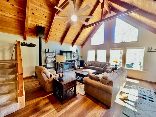 a living room with furniture a wooden floor and next to a window