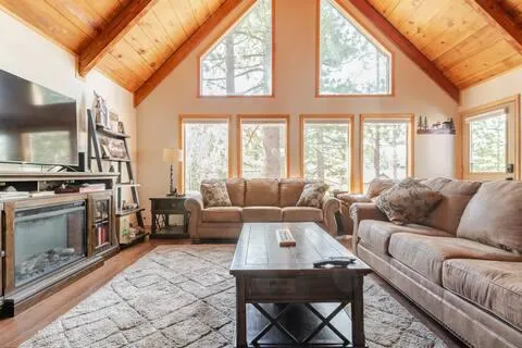 a living room with furniture a flat screen tv and a floor to ceiling window