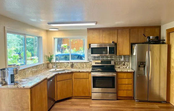 a kitchen with stainless steel appliances granite countertop a refrigerator and a sink