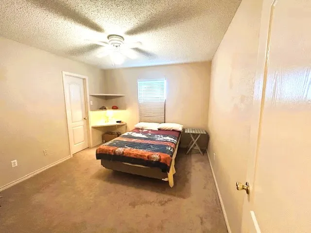 a bedroom with a bed and a ceiling fan