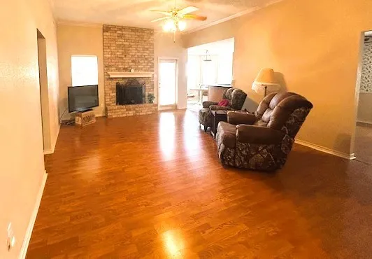 a living room with furniture a flat screen tv and a floor to ceiling window