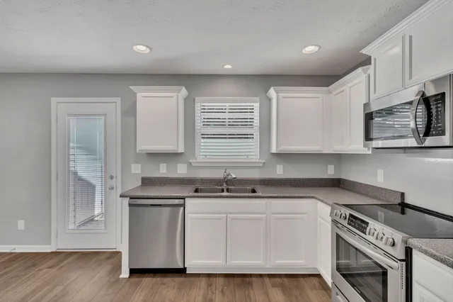 a view of a hallway with wooden floor and staircase