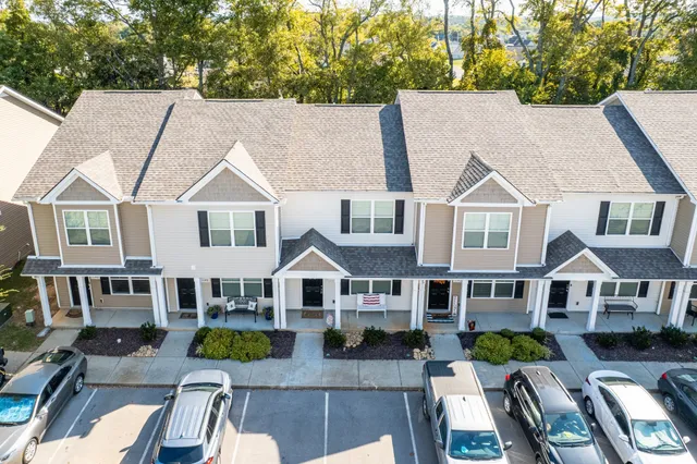 a view of multiple houses with deck and yard