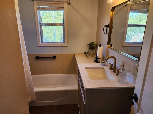 a bathroom with a sink a bathtub and a window