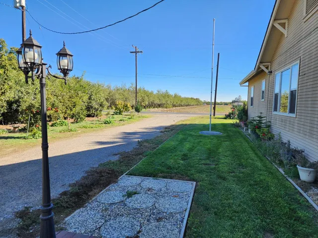 a view of a house with a yard and a car park