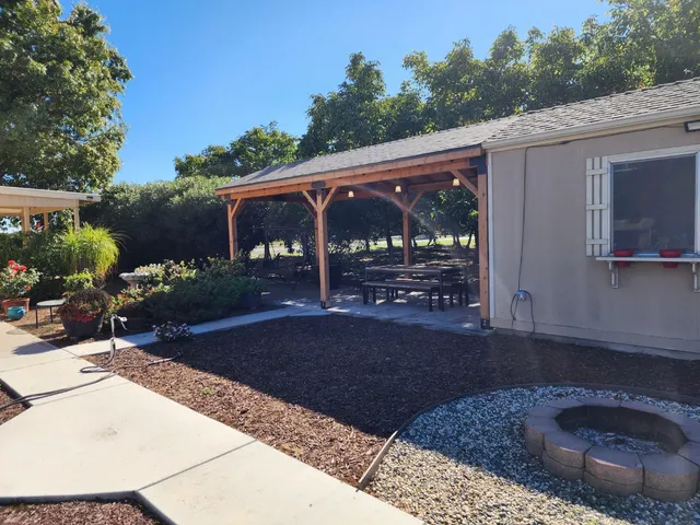 a view of a backyard with table and chairs potted plants