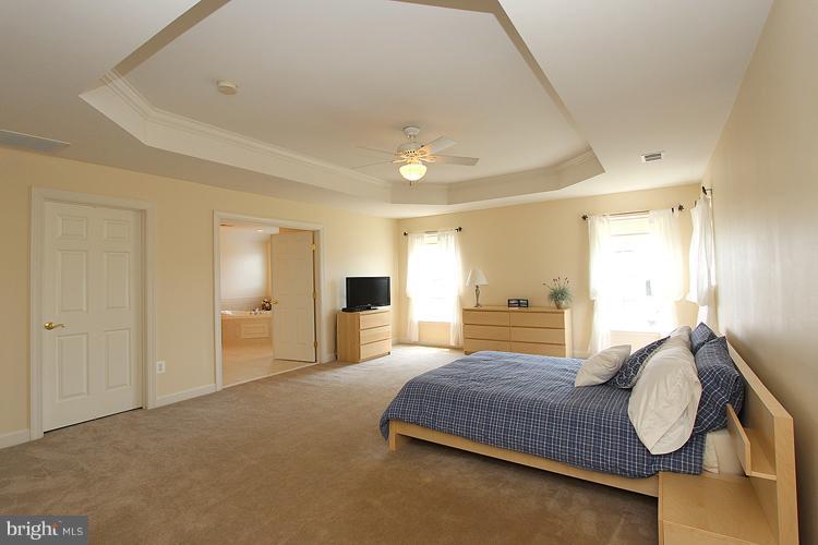 14422 Autumn Crest Road Boyds, MD 20841 - Photo 9 of 24 a bedroom with a bed and dresser with mirror