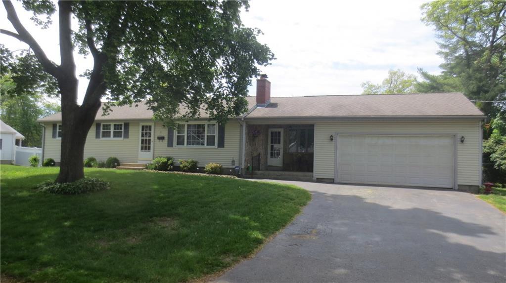 a front view of a house with a garden and trees