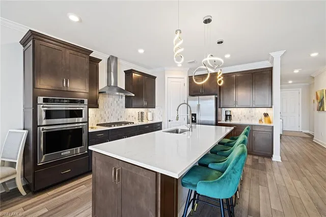 a kitchen with kitchen island a counter space a sink appliances and cabinets